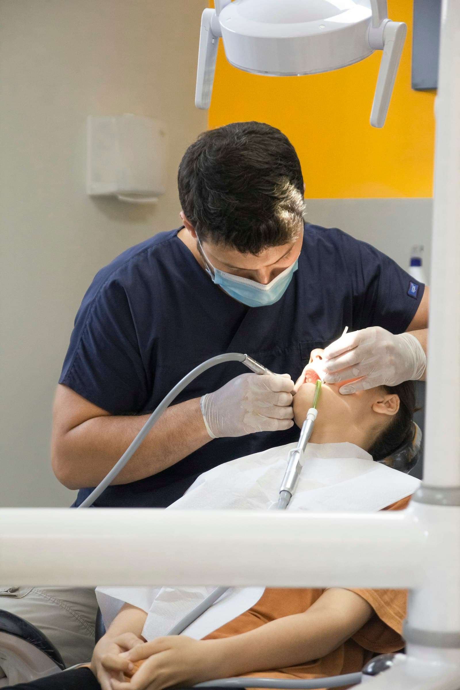 A dentist treating a patient in the dental chair